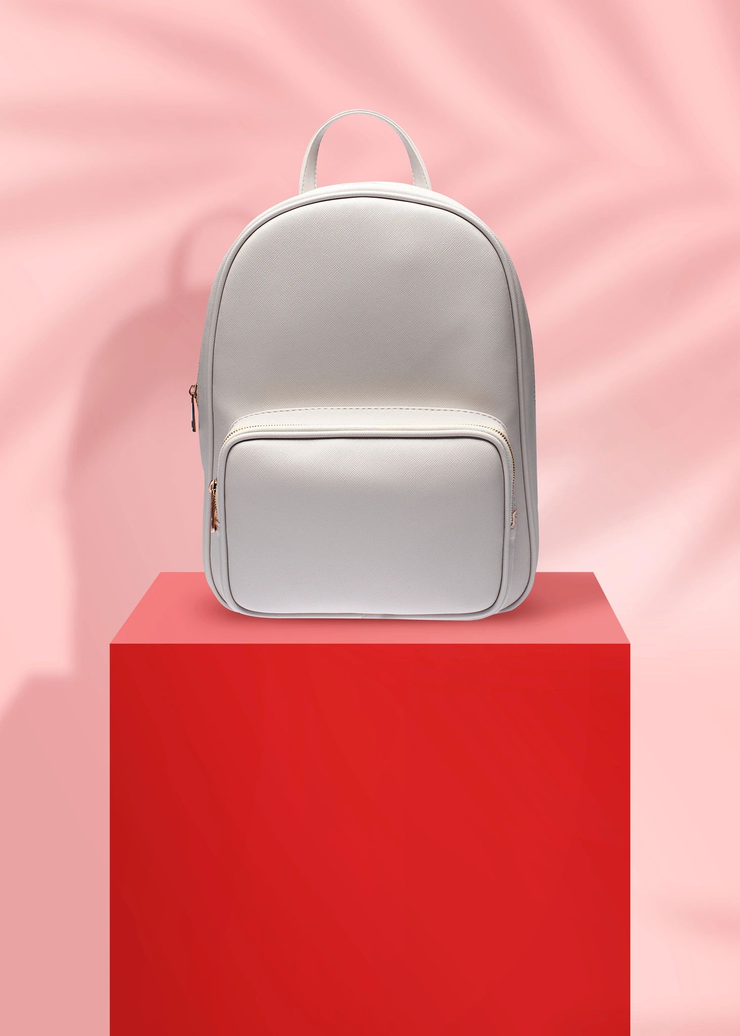 White designer backpack on a bold pink fashion background