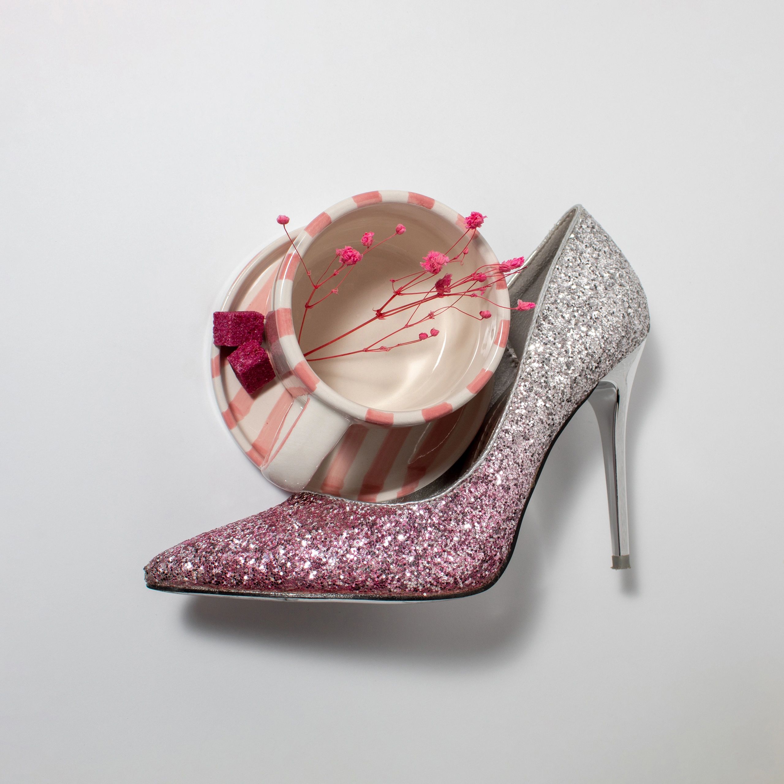 Pink glitter high heel shoe with coffee cup and flowers
