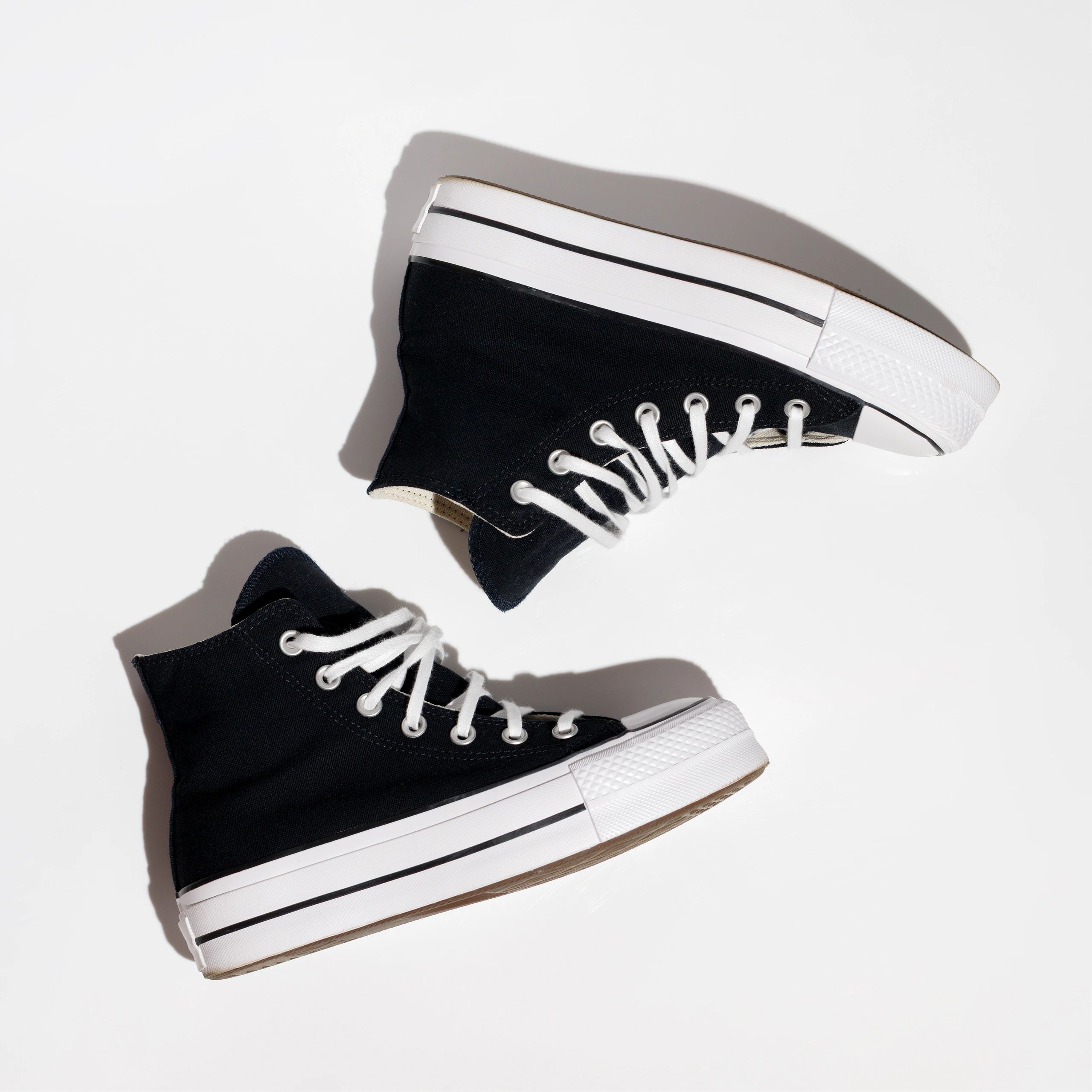 Black high-top canvas sneakers in a clean flat lay